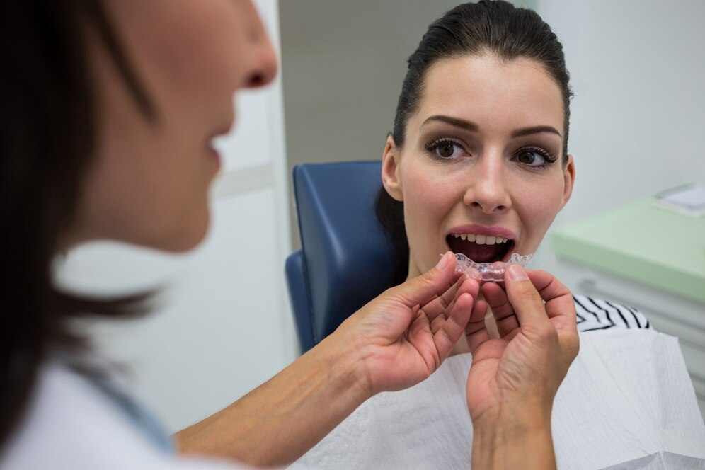 dentista-ajudando-um-paciente-a-usar-aparelho-invisivel_107420-65666